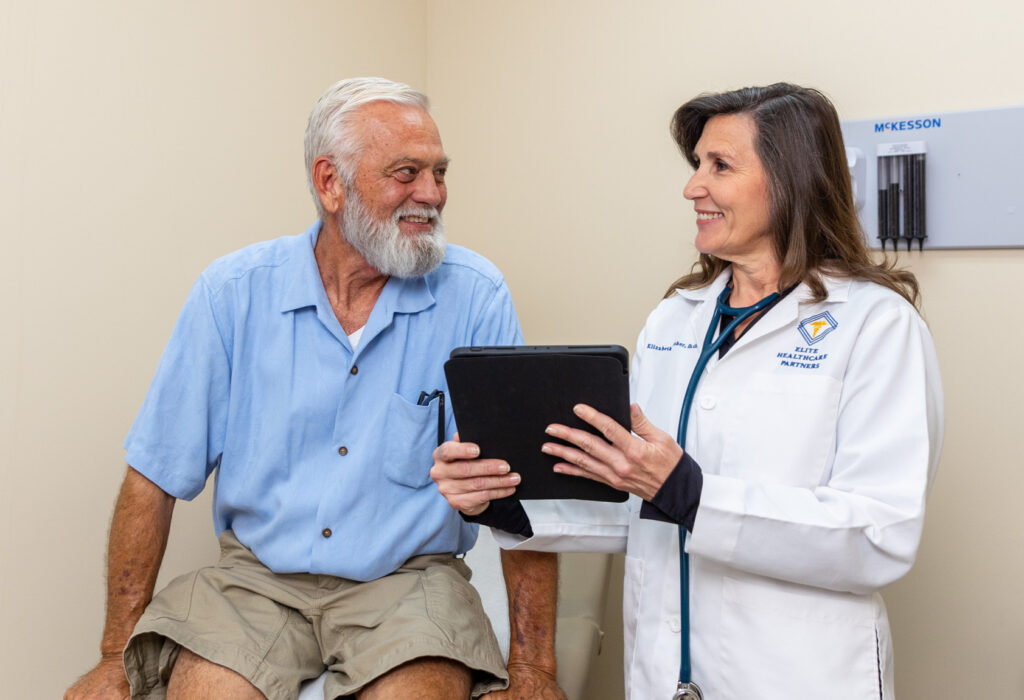 A female doctor speaking with a male patient during an in-office visit, reflecting the personalized care experience of concierge medicine in Lake Worth, FL.